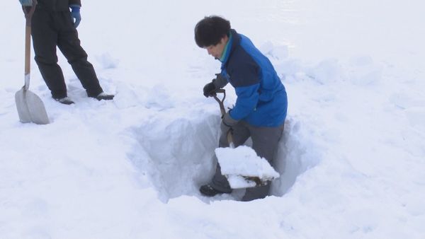 雪を掘る前田